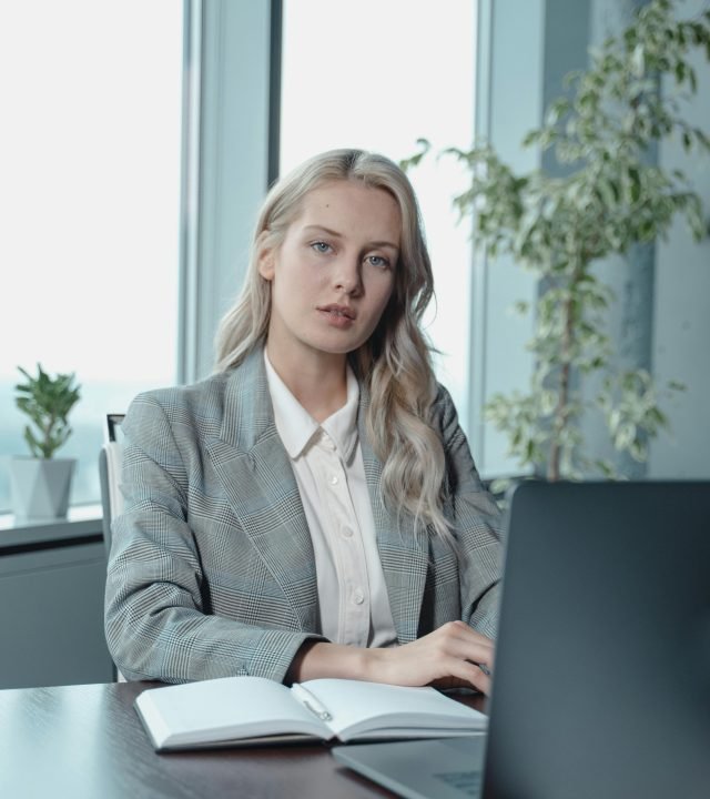 Portrait of a confident businesswoman working on her laptop in a modern office setting.